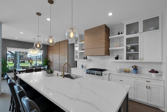 26511 Meadow Ln, Katy, TX 77494 - kitchen featuring open shelves, a sink, tasteful backsplash, an island with sink, and premium range hood
