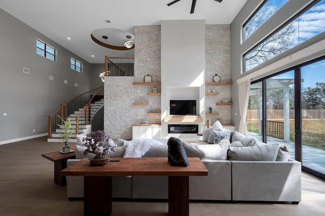 26511 Meadow Ln, Katy, TX 77494 - living area featuring a towering ceiling, stairs, ceiling fan, baseboards, and wood finished floors