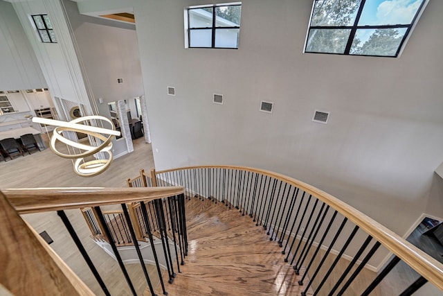 26511 Meadow Ln, Katy, TX 77494 - staircase featuring wood finished floors, a towering ceiling, and a chandelier