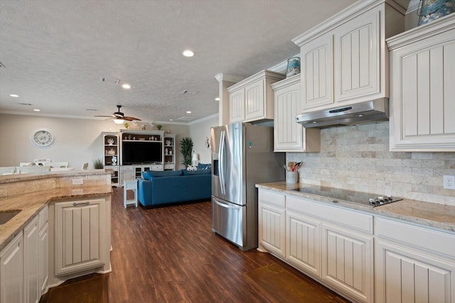 3025 Carioca Ct, Crystal Beach, TX 77650 - kitchen featuring black electric stovetop, under cabinet range hood, stainless steel fridge, ceiling fan, and dark wood-style flooring