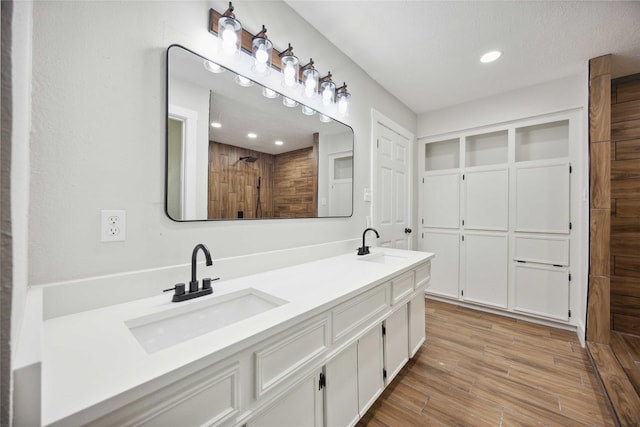 7907 12th Fairway Ln, Humble, TX 77346 - bathroom featuring wood finished floors, double vanity, recessed lighting, and tiled shower