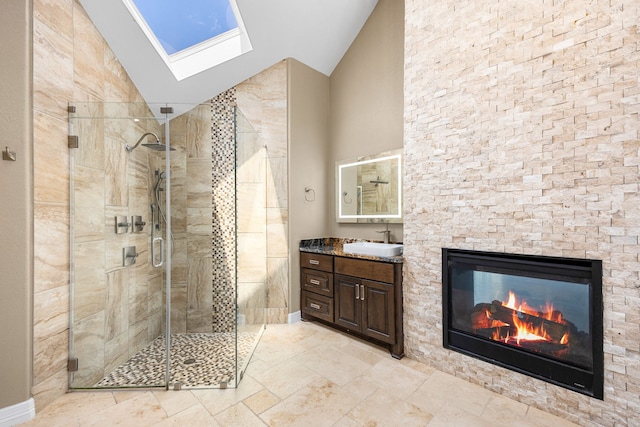 2911 S Saddlebrook Ln, Katy, TX 77494 - full bath featuring a stall shower, vanity, a skylight, high vaulted ceiling, and a glass covered fireplace