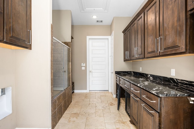 2911 S Saddlebrook Ln, Katy, TX 77494 - kitchen with stone tile floors, dark brown cabinets, dark stone counters, and recessed lighting