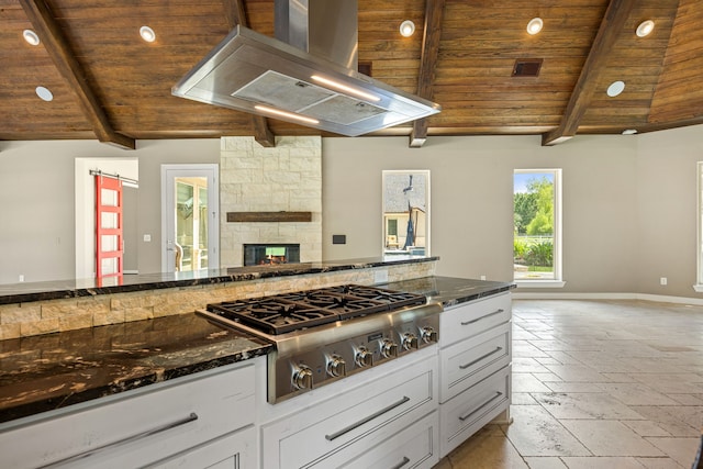 2911 S Saddlebrook Ln, Katy, TX 77494 - kitchen with stainless steel gas stovetop, extractor fan, open floor plan, wood ceiling, and a fireplace