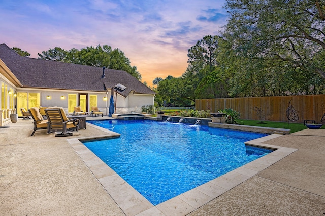 2911 S Saddlebrook Ln, Katy, TX 77494 - pool at dusk featuring a patio, a fenced backyard, and a pool with connected hot tub
