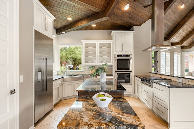 2911 S Saddlebrook Ln, Katy, TX 77494 - kitchen with a wood ceiling with exposed beams, stainless steel appliances, a peninsula, dark stone counters, and decorative backsplash