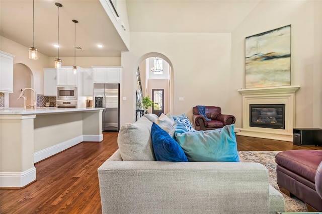 9811 Mount Shasta, Missouri City, TX 77459 - living room with arched walkways, dark wood finished floors, and vaulted ceiling