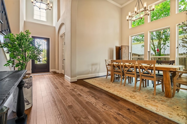 9811 Mount Shasta, Missouri City, TX 77459 - dining space featuring a chandelier, a towering ceiling, hardwood / wood-style flooring, and ornamental molding