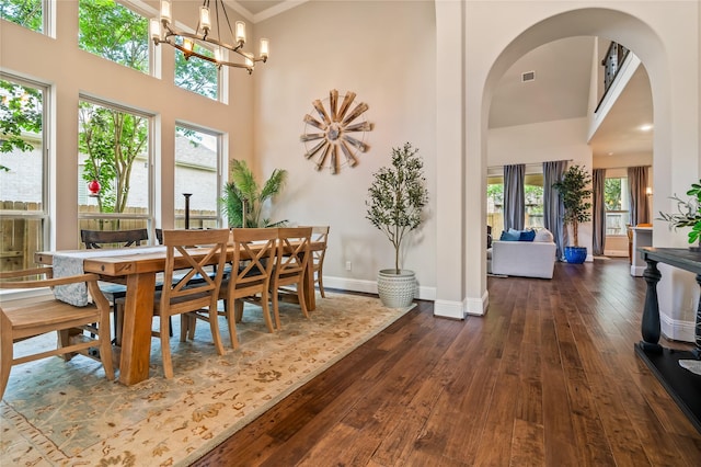 9811 Mount Shasta, Missouri City, TX 77459 - dining room with a high ceiling, arched walkways, dark wood-type flooring, plenty of natural light, and a chandelier
