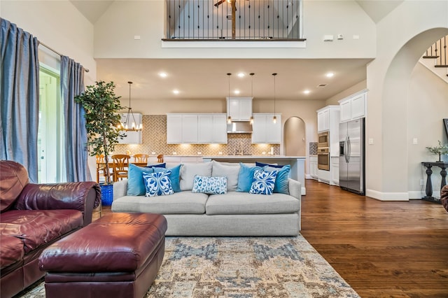 9811 Mount Shasta, Missouri City, TX 77459 - living area with high vaulted ceiling, dark wood finished floors, arched walkways, and a chandelier