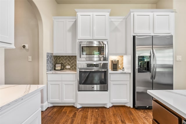 9811 Mount Shasta, Missouri City, TX 77459 - kitchen with appliances with stainless steel finishes, dark wood-style floors, backsplash, white cabinetry, and arched walkways