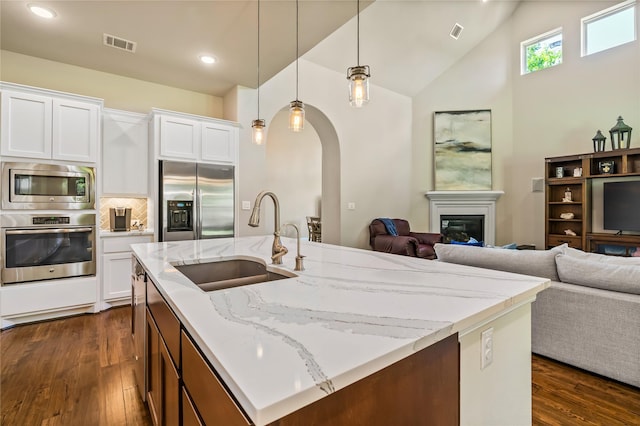 9811 Mount Shasta, Missouri City, TX 77459 - kitchen featuring stainless steel appliances, dark wood-style floors, open floor plan, light stone countertops, and recessed lighting
