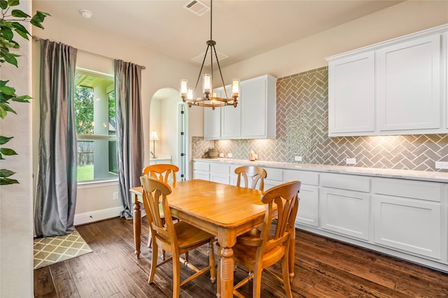9811 Mount Shasta, Missouri City, TX 77459 - dining space with dark wood-style floors, a chandelier, and arched walkways