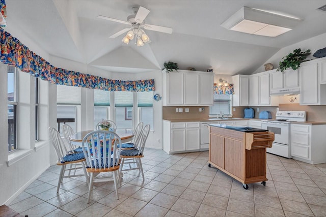 kitchen with white electric range, vaulted ceiling, under cabinet range hood, light countertops, and a kitchen island