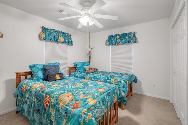 carpeted bedroom with a closet, baseboards, and a ceiling fan