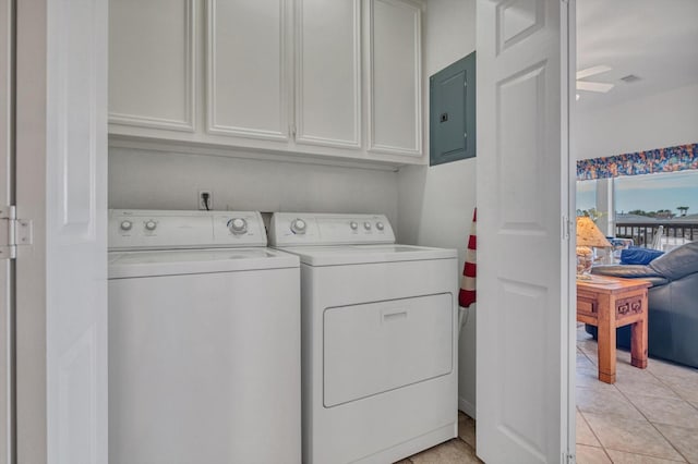 laundry room with cabinet space, electric panel, washer and clothes dryer, and light tile patterned floors
