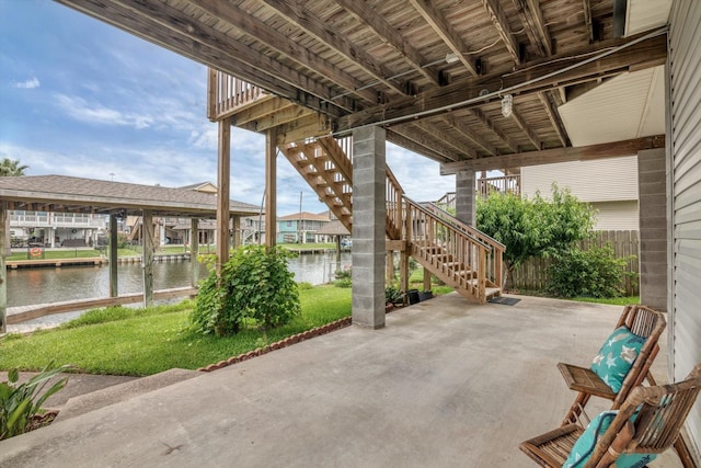 view of patio with stairs and a water view