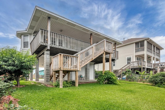 back of property featuring stairway, a lawn, and a deck