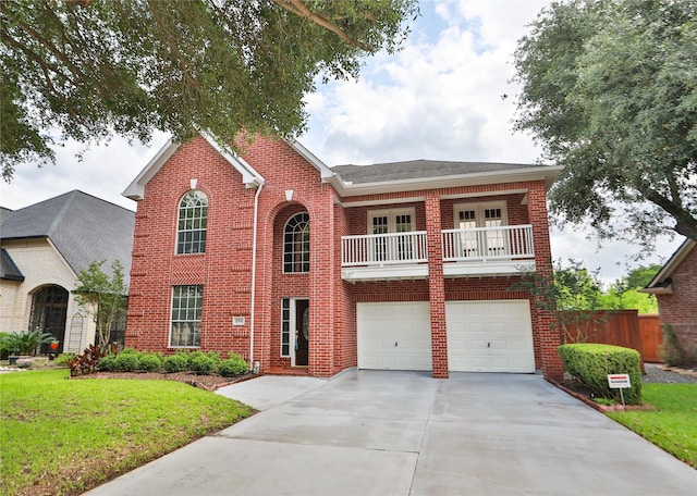 view of front of home with brick siding, an attached garage, a balcony, driveway, and french doors