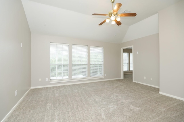 spare room featuring ceiling fan, carpet, baseboards, and lofted ceiling
