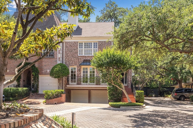 17 Pine Briar Cir, Houston, TX 77056 - view of front facade with decorative driveway, brick siding, a garage, a chimney, and stairs