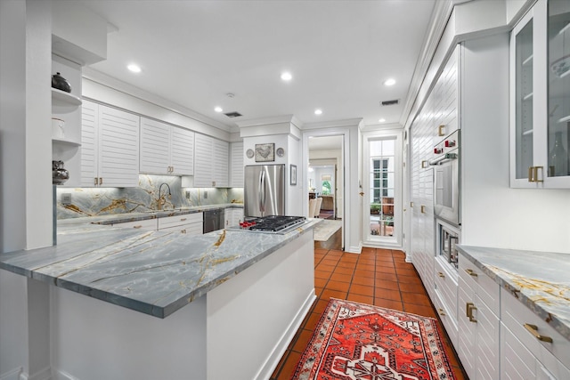 17 Pine Briar Cir, Houston, TX 77056 - kitchen with stainless steel appliances, open shelves, a peninsula, decorative backsplash, and white cabinetry