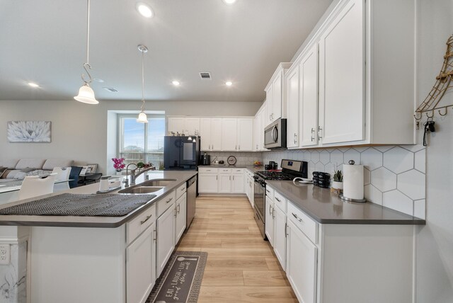 24323 Salts Mill Dr, Katy, TX 77493 - kitchen featuring stainless steel appliances, a sink, dark countertops, white cabinets, and backsplash