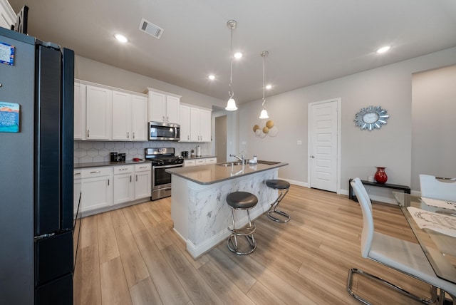 24323 Salts Mill Dr, Katy, TX 77493 - kitchen with appliances with stainless steel finishes, a sink, light wood-type flooring, white cabinetry, and recessed lighting
