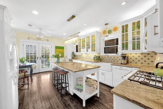 418 Byrne St, Houston, TX 77009 - kitchen with a sink, french doors, white appliances, white cabinetry, and a kitchen breakfast bar