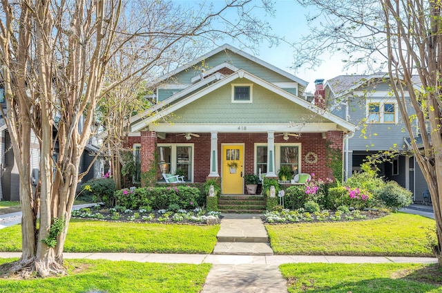 418 Byrne St, Houston, TX 77009 - view of front of house featuring a porch, a front lawn, ceiling fan, and brick siding