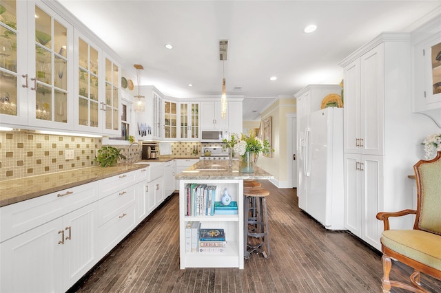 418 Byrne St, Houston, TX 77009 - kitchen with white appliances, white cabinetry, decorative backsplash, light stone countertops, and crown molding