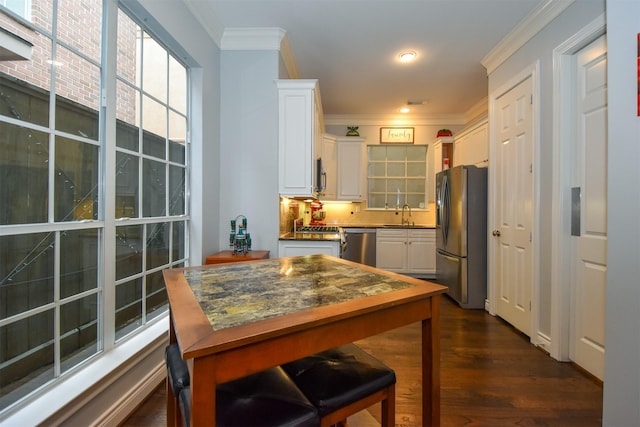 3226 Pemberton Circle Dr, Houston, TX 77025 - kitchen featuring appliances with stainless steel finishes, white cabinetry, ornamental molding, dark countertops, and dark wood-style floors