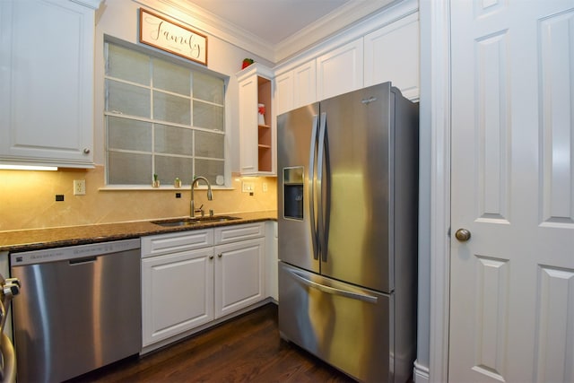 3226 Pemberton Circle Dr, Houston, TX 77025 - kitchen featuring stainless steel appliances, a sink, ornamental molding, white cabinetry, and dark stone counters
