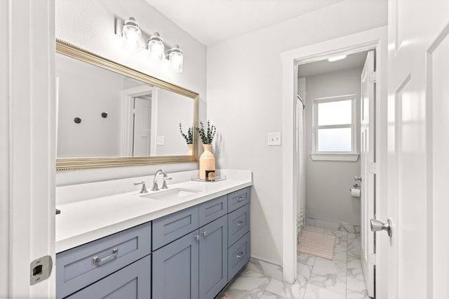 bathroom with marble finish floors, vanity, baseboards, and curtained shower