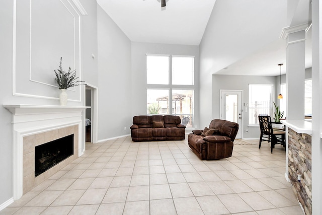 8742 Melting Shadows Ln, Houston, TX 77095 - living room with a towering ceiling, a tile fireplace, light tile patterned floors, and baseboards