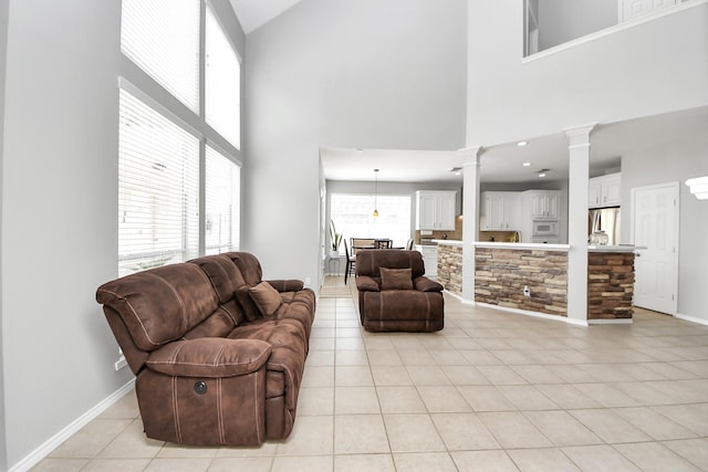 8742 Melting Shadows Ln, Houston, TX 77095 - living area featuring ornate columns, light tile patterned floors, a high ceiling, and baseboards