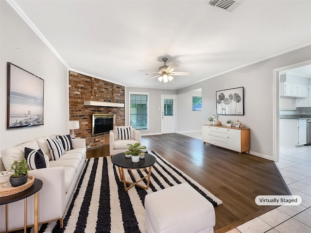 141 20th Ave N, Texas City, TX 77590 - living area with ornamental molding, a ceiling fan, a brick fireplace, light wood-style flooring, and baseboards
