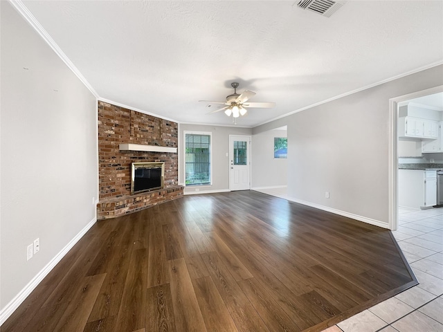 141 20th Ave N, Texas City, TX 77590 - unfurnished living room with a ceiling fan, crown molding, baseboards, a brick fireplace, and wood finished floors