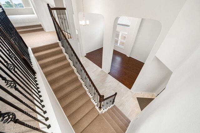 2107 Pearl Bay Ct, Pearland, TX 77584 - stairs with arched walkways, plenty of natural light, and a chandelier