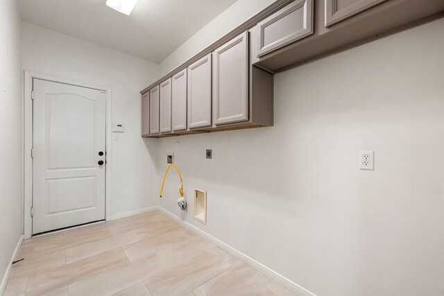 2107 Pearl Bay Ct, Pearland, TX 77584 - laundry room with hookup for a gas dryer, hookup for an electric dryer, cabinet space, and baseboards