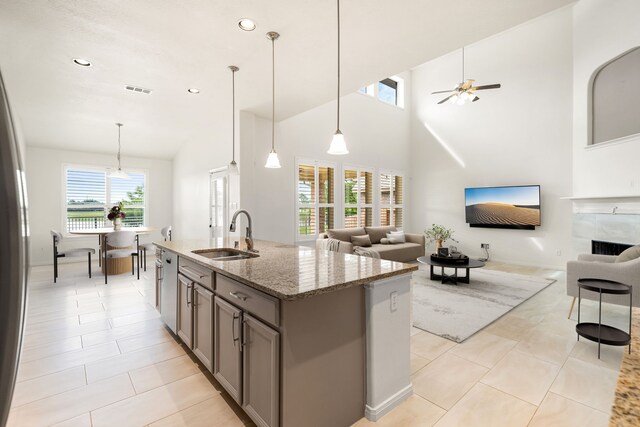 2107 Pearl Bay Ct, Pearland, TX 77584 - kitchen featuring a sink, open floor plan, gray cabinets, stone counters, and light tile patterned flooring