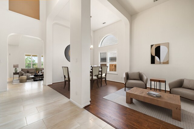 2107 Pearl Bay Ct, Pearland, TX 77584 - living room featuring arched walkways, a high ceiling, and tile patterned flooring