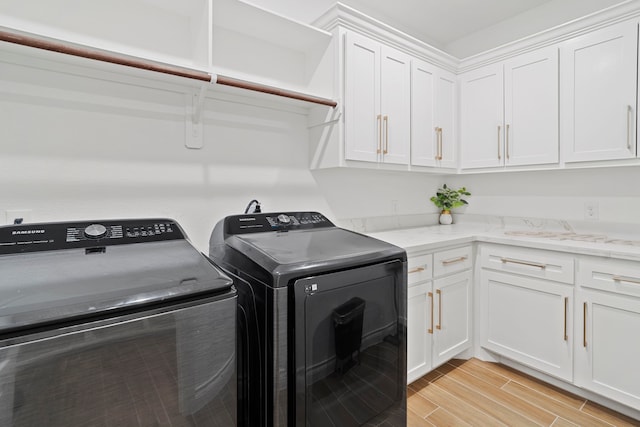 9603 Neon Moon Dr, Needville, TX 77461 - clothes washing area featuring cabinet space, independent washer and dryer, and light wood-style floors