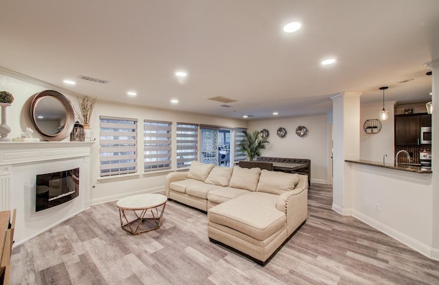 2519 Bradburn Hill Ln, Houston, TX 77014 - living room with light wood-type flooring, a glass covered fireplace, baseboards, recessed lighting, and ornamental molding