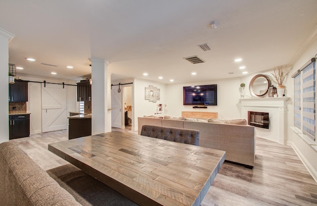 2519 Bradburn Hill Ln, Houston, TX 77014 - dining area with a barn door, recessed lighting, light wood-type flooring, a glass covered fireplace, and crown molding