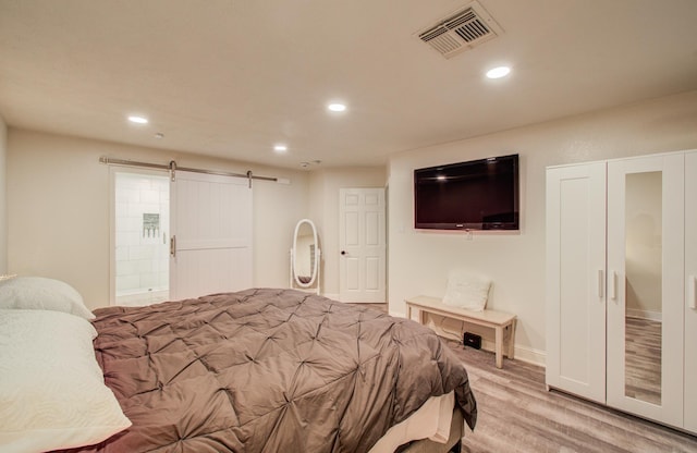 2519 Bradburn Hill Ln, Houston, TX 77014 - bedroom with a barn door, light wood finished floors, recessed lighting, and baseboards