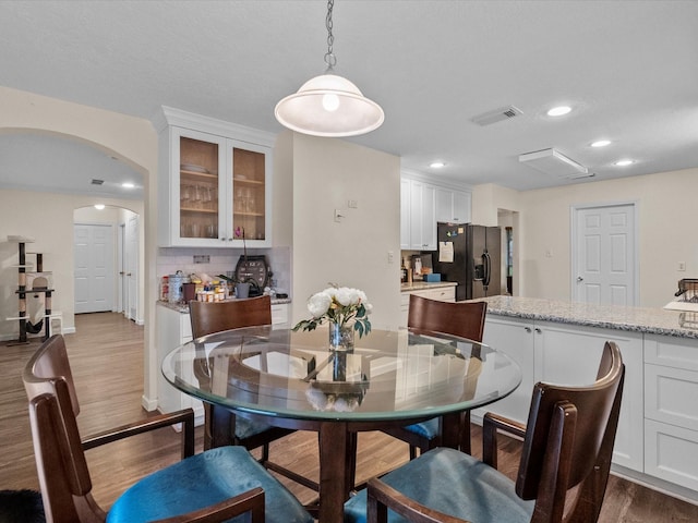1814 Oak Valley Dr, Kemah, TX 77565 - dining space featuring arched walkways, dark wood-type flooring, and recessed lighting
