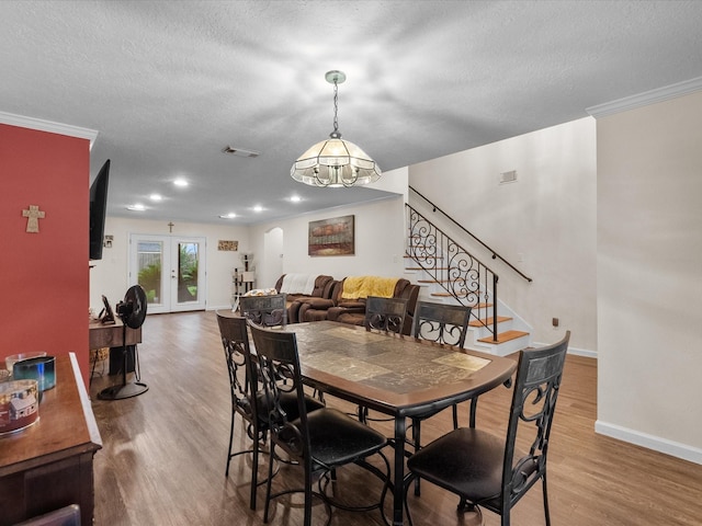 1814 Oak Valley Dr, Kemah, TX 77565 - dining room featuring baseboards, wood finished floors, stairway, a textured ceiling, and ornamental molding
