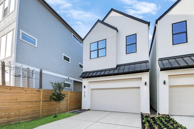 view of front of home featuring a standing seam roof, an attached garage, fence, concrete driveway, and metal roof