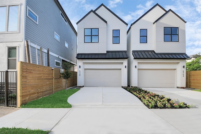 view of front of home featuring a standing seam roof, fence, an attached garage, and driveway